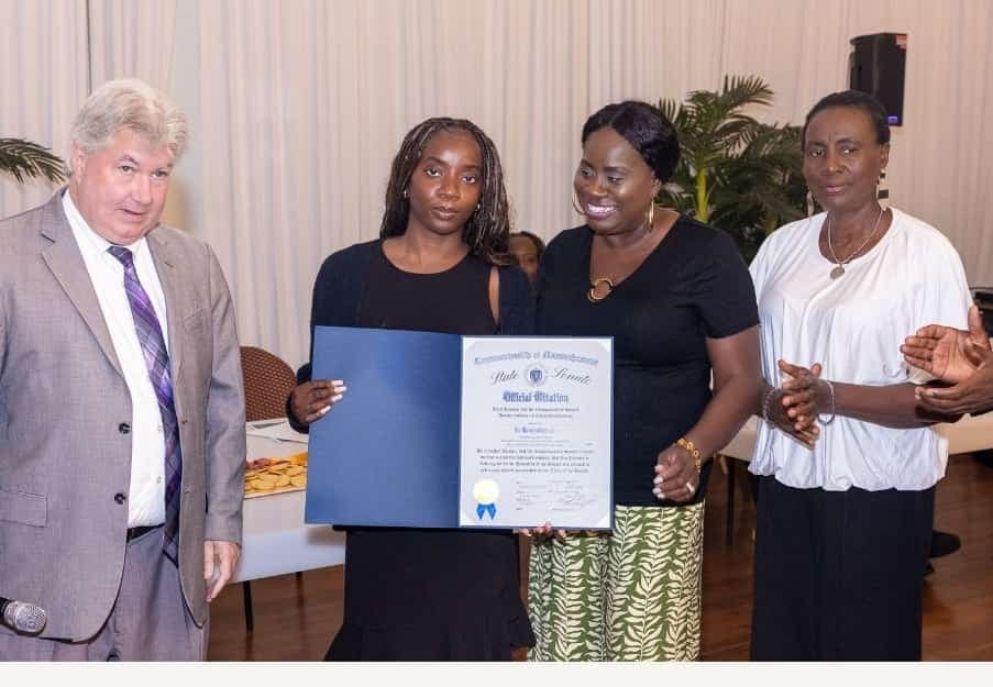 A young leader holds her Official Citation with Senator Michael Brady and family.