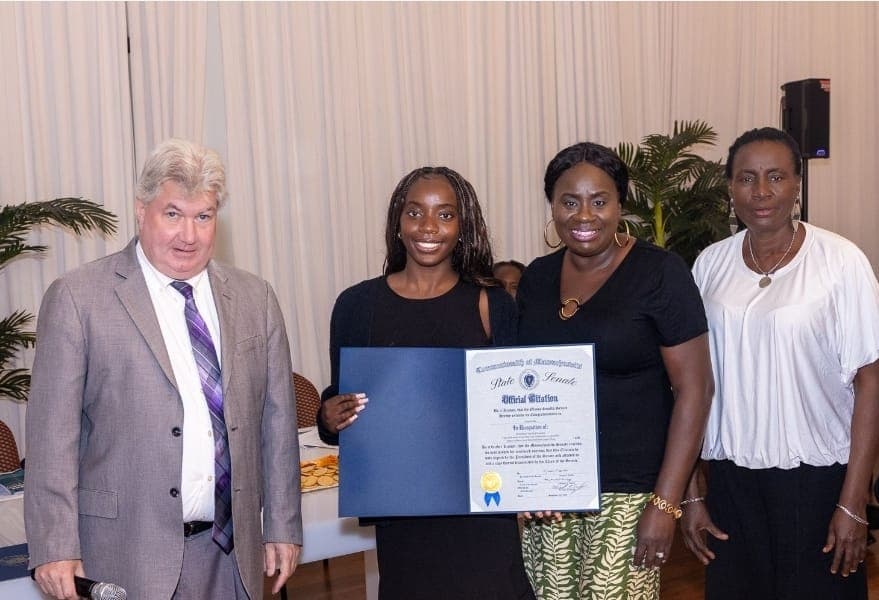 A young leader holds her Official Citation with Senator Michael Brady and family.