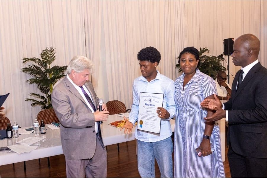 A young author holds his Official Citation while Senator Michael Brady speaks.