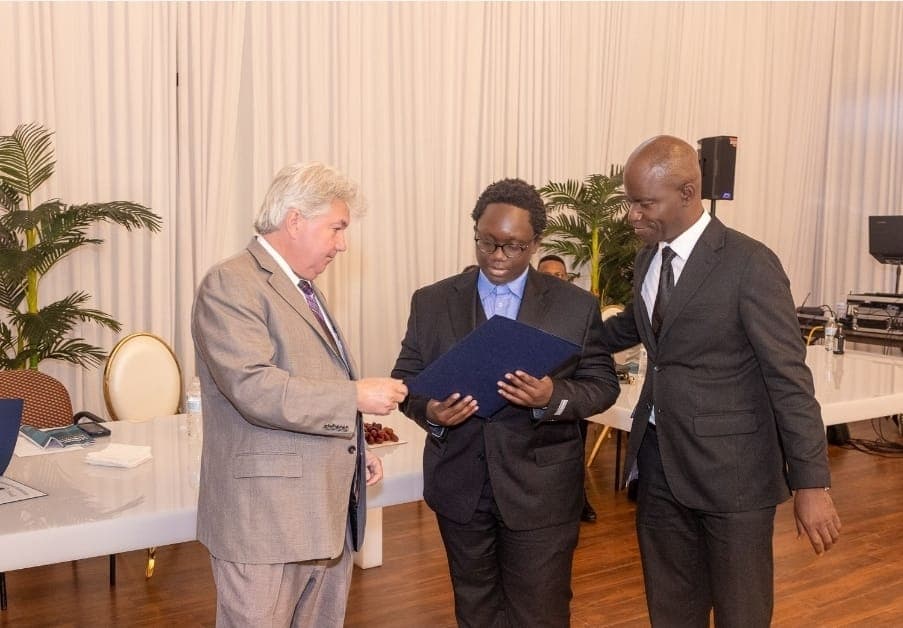 Senator Michael Brady presents a citation folder to a young leader.
