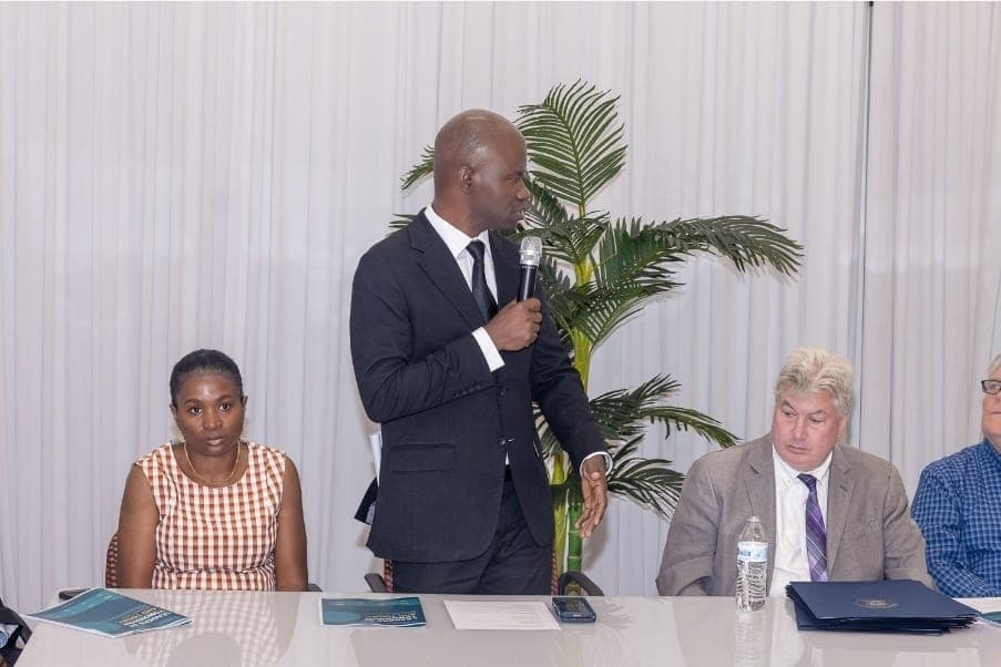 Charles Awodu speaks at the head table with Senator Michael Brady.