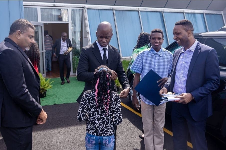 Charles Awodu greets a young guest outside the venue.